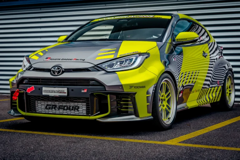 Aggressive Front-Dreiviertel-Ansicht des Breitbau Toyota GR Yaris GR-Four von CoastRacing; limettenfarbene Aero-Details, GR-Intercooler und tiefe Track-Position.